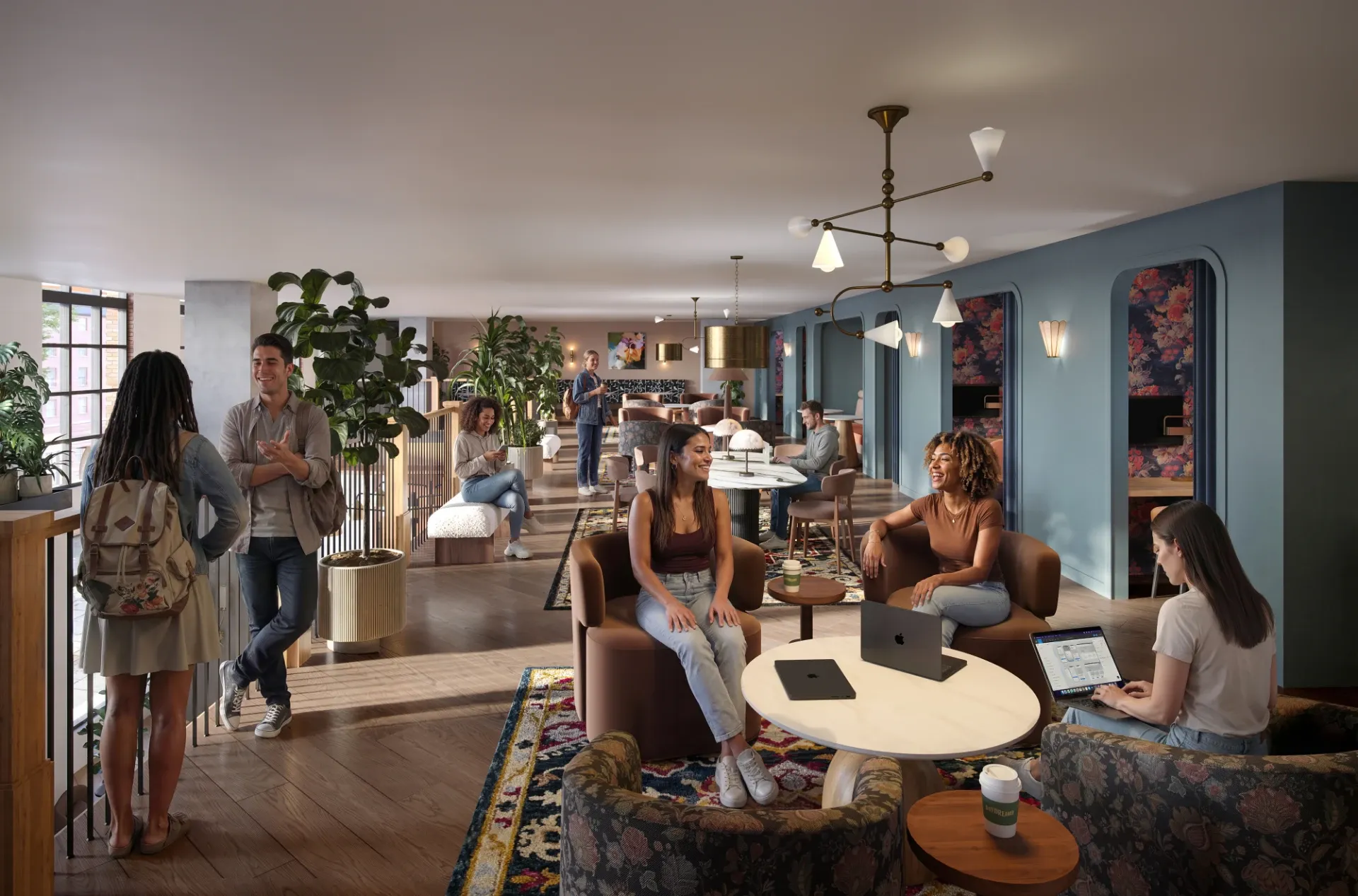 A modern lounge with people socializing, working on laptops, and relaxing on sofas and chairs—ideal for UMich Off-Campus Housing residents. Wooden floors, plants, round tables, and warm lighting create a welcoming, collaborative atmosphere.