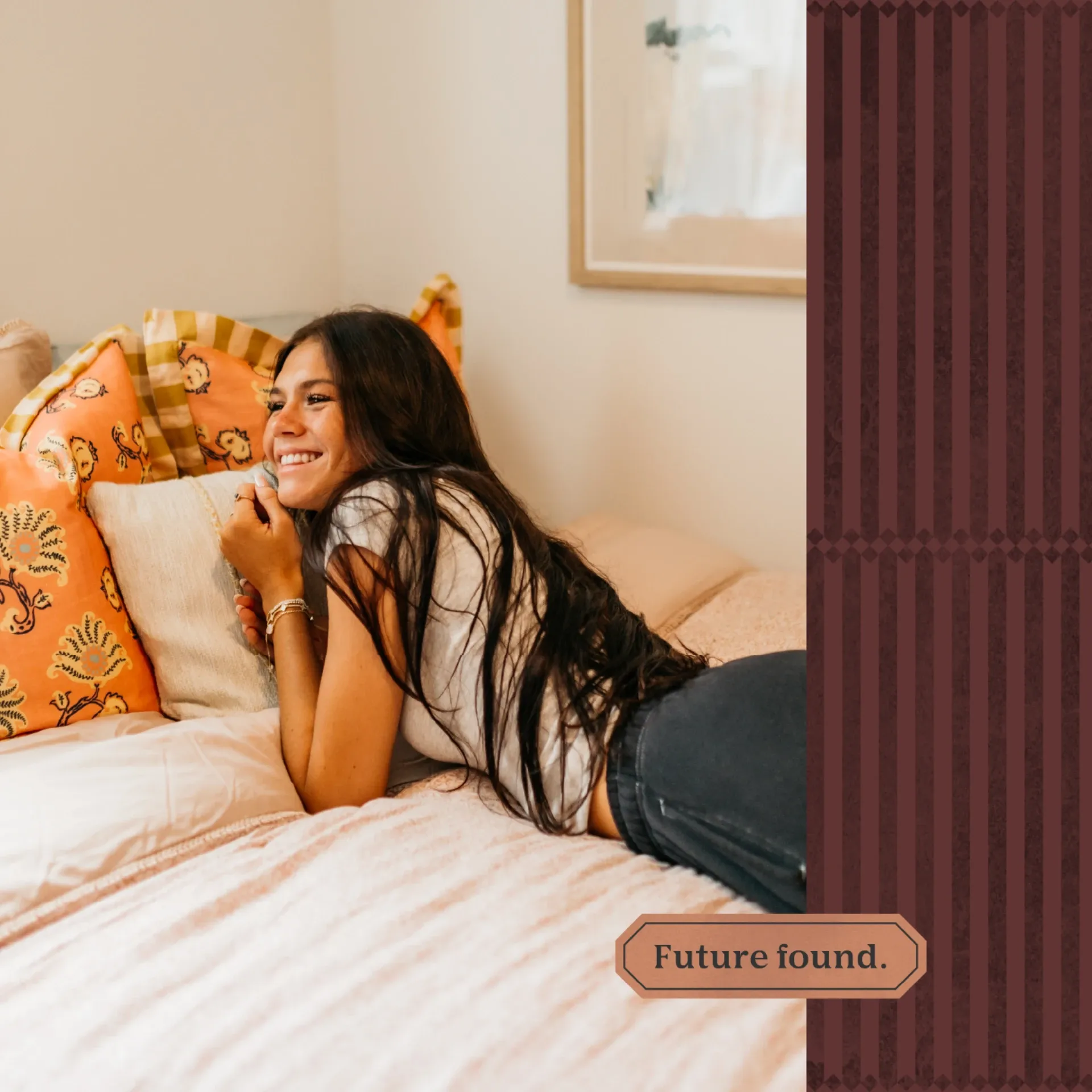 A smiling woman with long dark hair lies on a bed with colorful pillows, wearing a white top and dark jeans. The text Future found. appears on a patterned brown background to the right, celebrating UMich Off-Campus Housing.