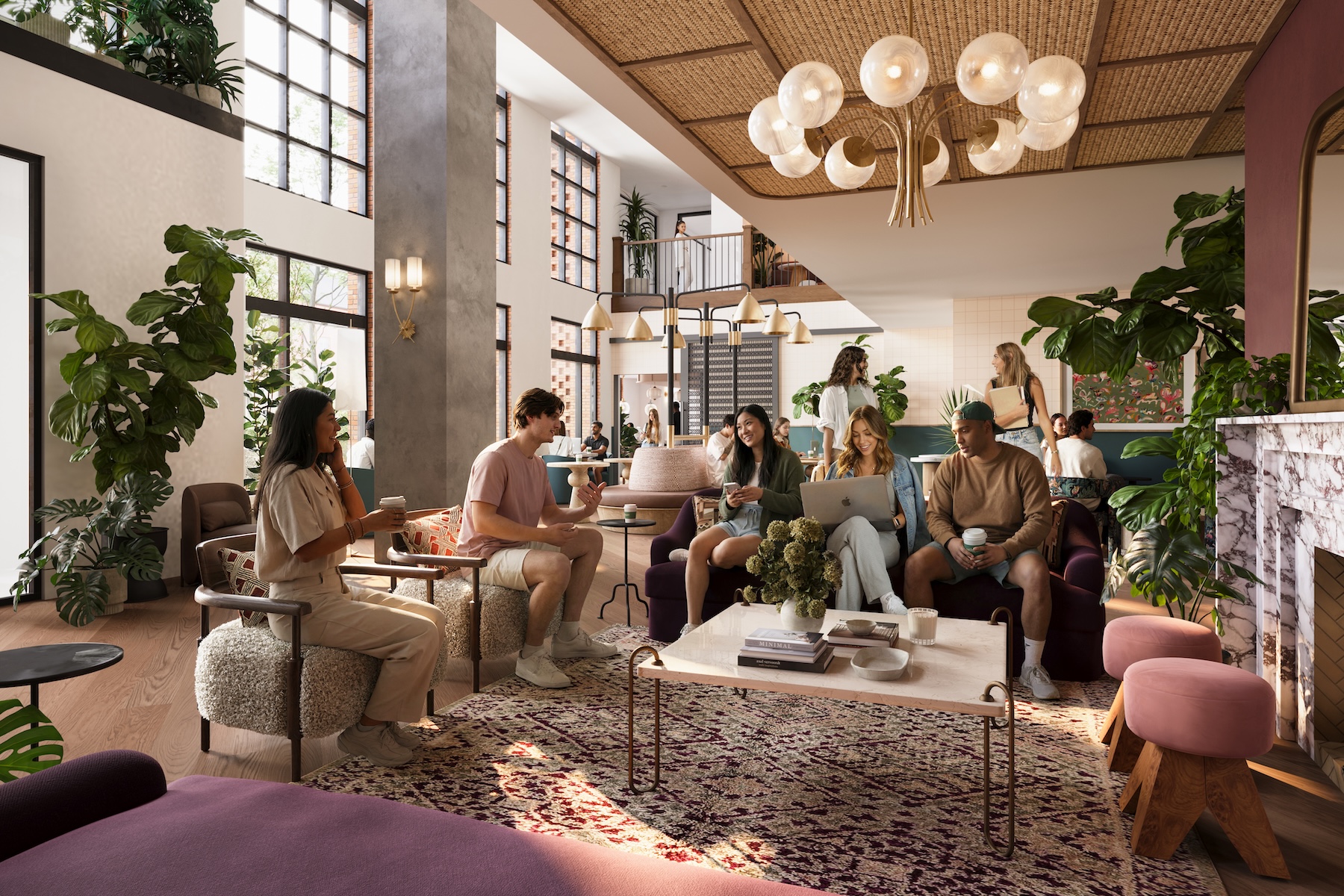 A group of people relax and socialize in a bright, modern UMich Off-Campus Housing lounge with large windows, plants, comfortable seating, and warm lighting. Some are chatting, others are using laptops or drinking coffee.