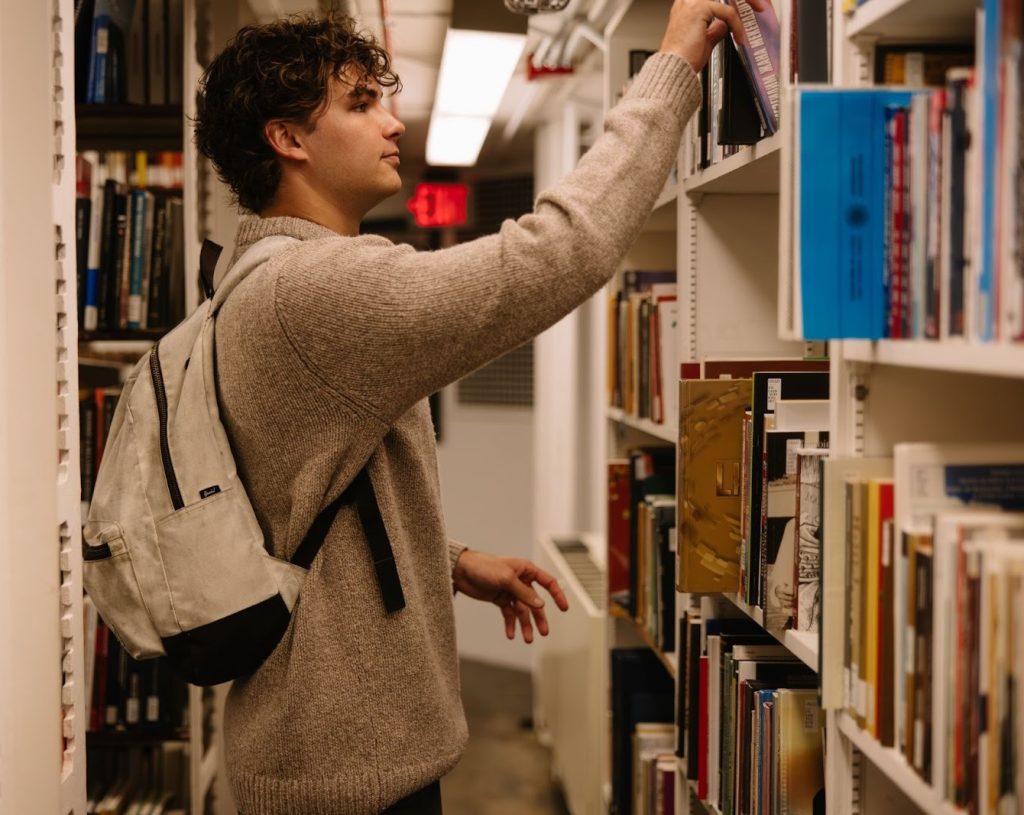 A UMich student reading a book in the Hatcher Graduate Library, a building that is located right off of the Diag.
