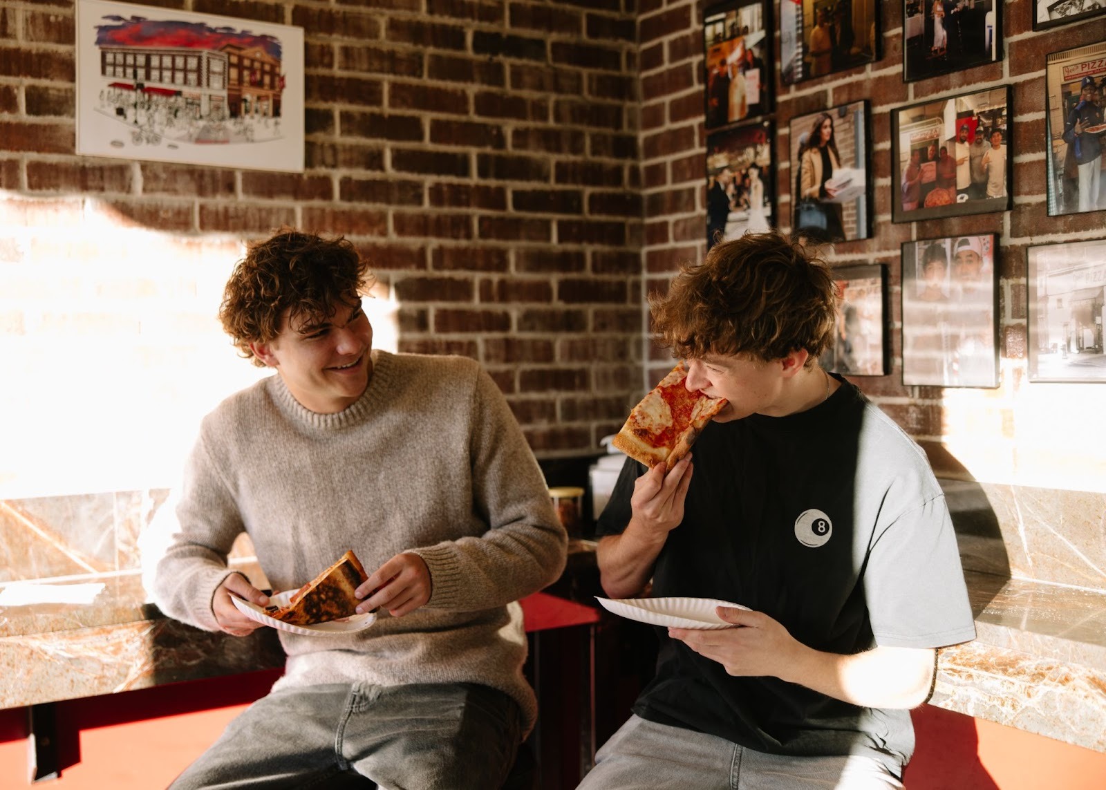 Two students enjoying pizza at Joe’s Pizza, a local Ann Arbor restaurant near the student apartment community, Rambler Ann Arbor. 