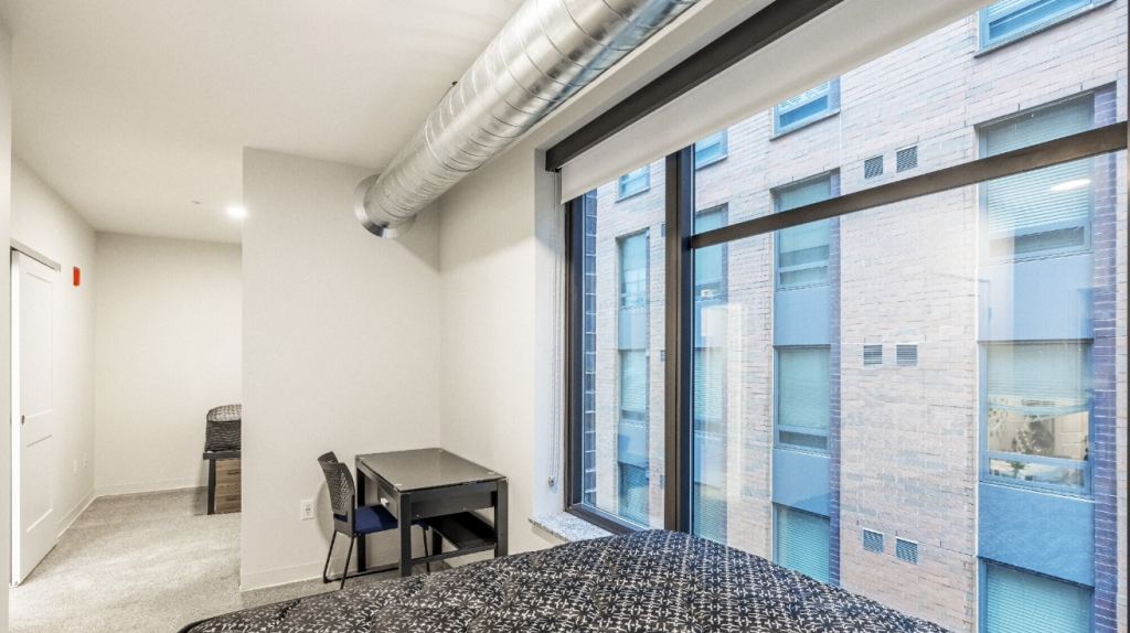 Vic Village South Ann Arbor student housing with modern kitchen, island seating, stainless steel appliances, and in-unit washer and dryer near UMich.