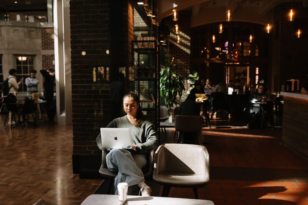 A University of Michigan student in the Union at Sweetwater Cafe studying on their computer.