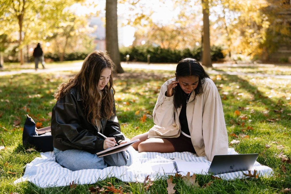 UMich students studying on the lawn in Law Quad during the Fall. 