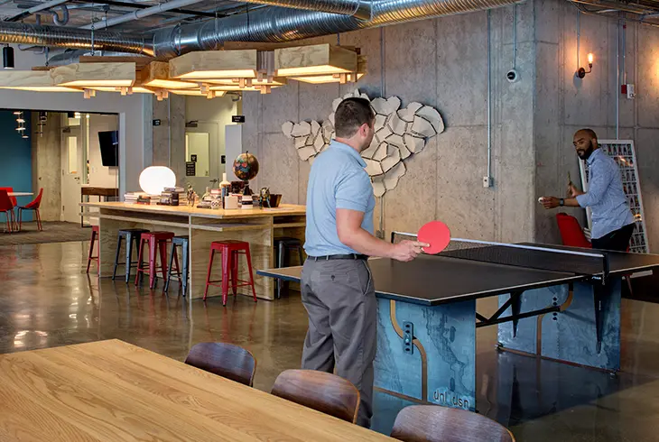 Foundry Lofts Ann Arbor student apartments community lounge with ping pong table, industrial-style interiors, shared workspace and social amenity space near the University of Michigan.