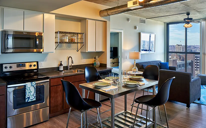 Foundry Lofts Ann Arbor student apartment interior with modern kitchen, stainless steel appliances, dining area and living room in downtown Ann Arbor near the University of Michigan.