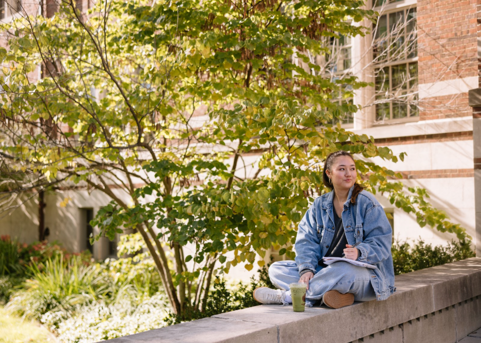 A University of Michigan student sitting outside of the Michigan Union, located on Central Campus in Ann Arbor. 