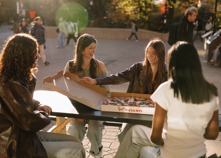 Three UMich students eating at Joe’s Pizza, a restaurant located near the Diag in Ann Arbor. 