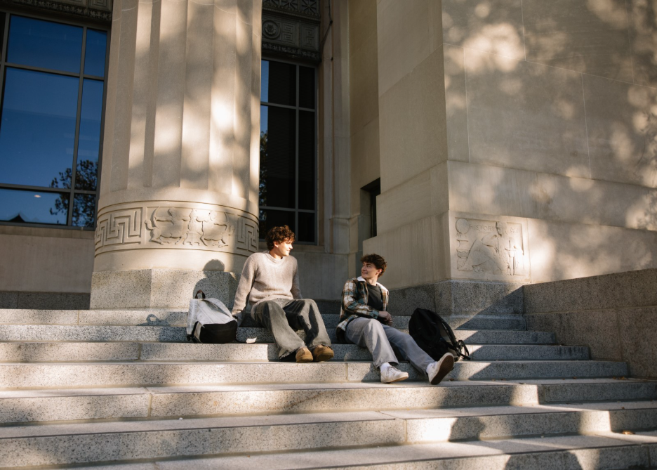 Two UMich students talking outside of Angell Hall, an academic building on Central Campus.  