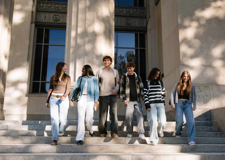 A group of UMich students walking out of Angell Hall, an academic building on Central Campus.