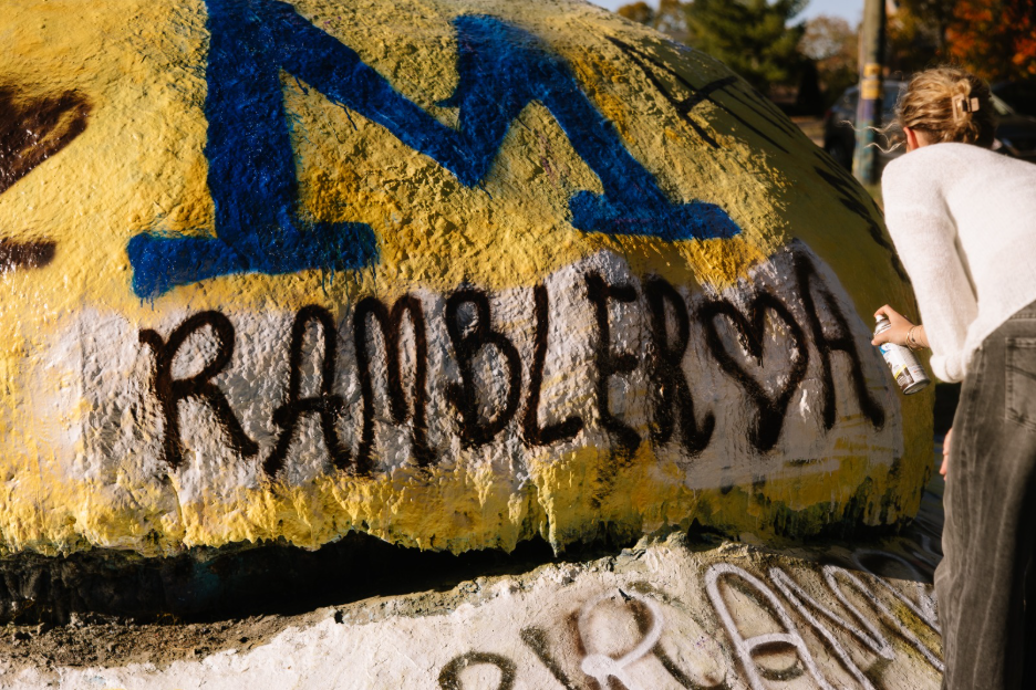 A UMich student painting the Rock, a campus tradition in Ann Arbor.