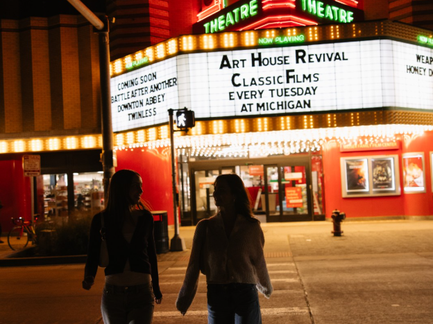 Two UMich students walking on State Street, a social and busy street near Central Campus.