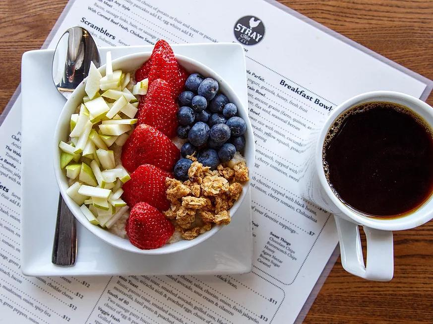 Breakfast bowl with fresh fruit, granola and coffee at The Hen in Ann Arbor, a student-friendly café known for brunch near the University of Michigan.