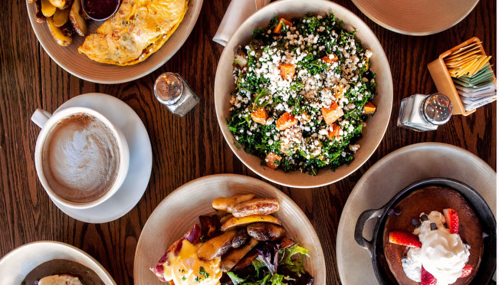 Assorted brunch plates and coffee spread across a table at Avalon Café and Kitchen, a brunch place for big groups.