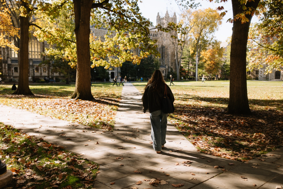 A University of Michigan student walking through the Law Quad, a space on Central Campus.
