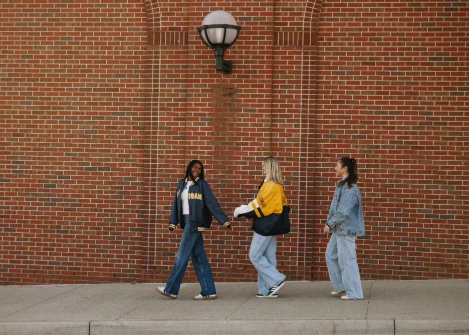 Three UMich students outside of the Michigan Stadium in Ann Arbor.