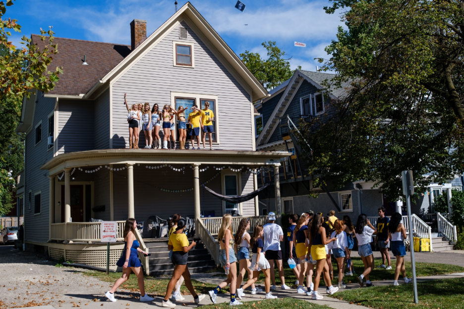 UMich students celebrating a Michigan game day at a student rental house in Ann Arbor.