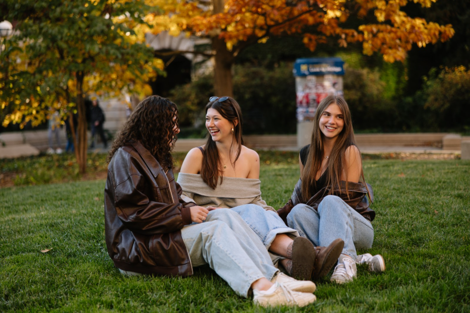 A group of University of Michigan students sitting outside near the Diag in Ann Arbor.  