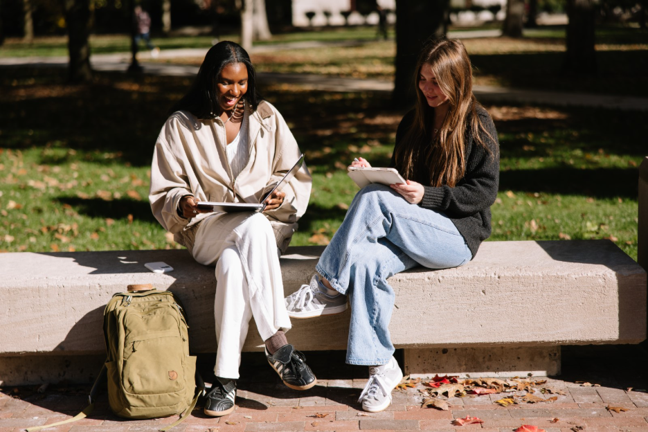 University of Michigan students look at laptops together on campus in Ann Arbor. 