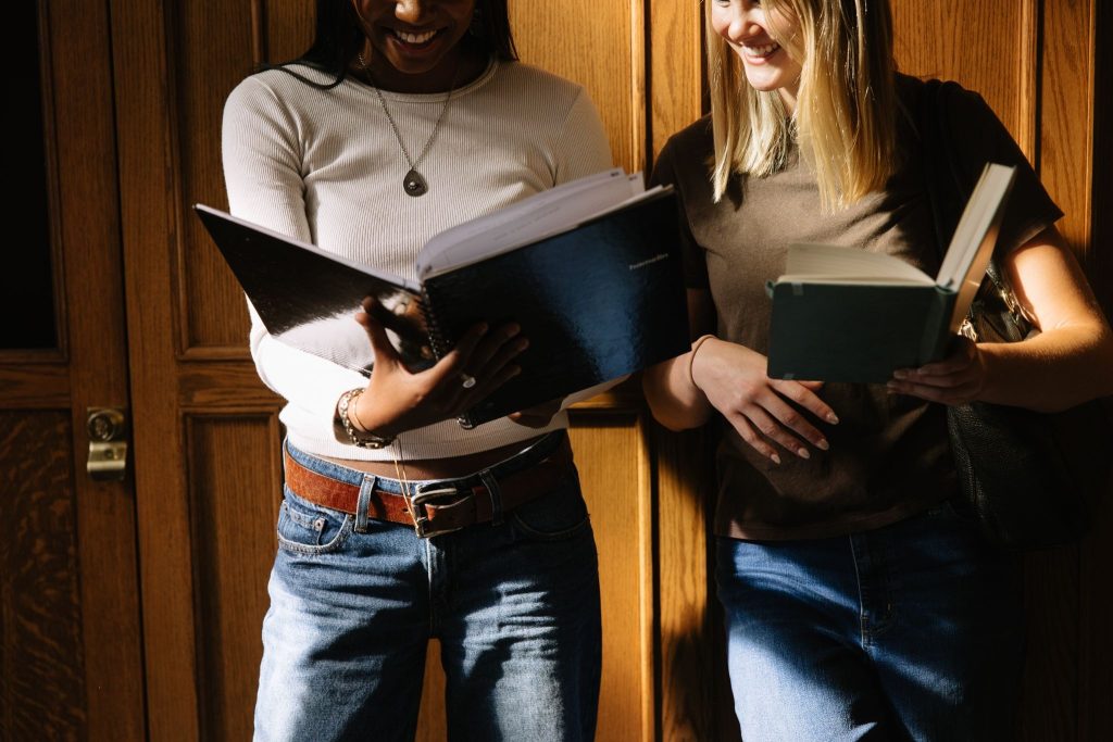 University of Michigan students look over a binder together on-campus in Ann Arbor.