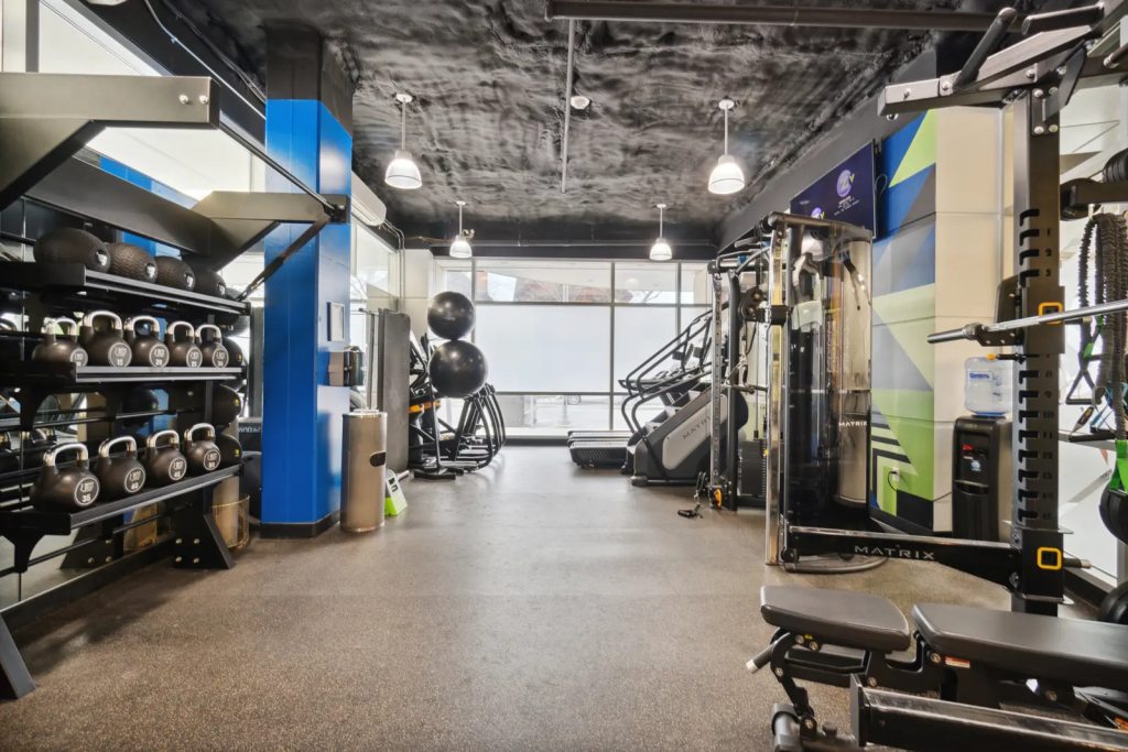 Z West apartment fitness center with cardio equipment, cable machines and free weights.