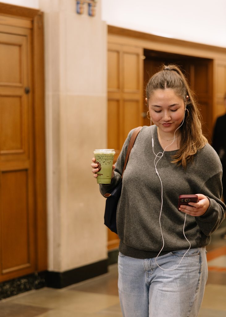 A UMich student walking through the Michigan Union on Central Campus.
