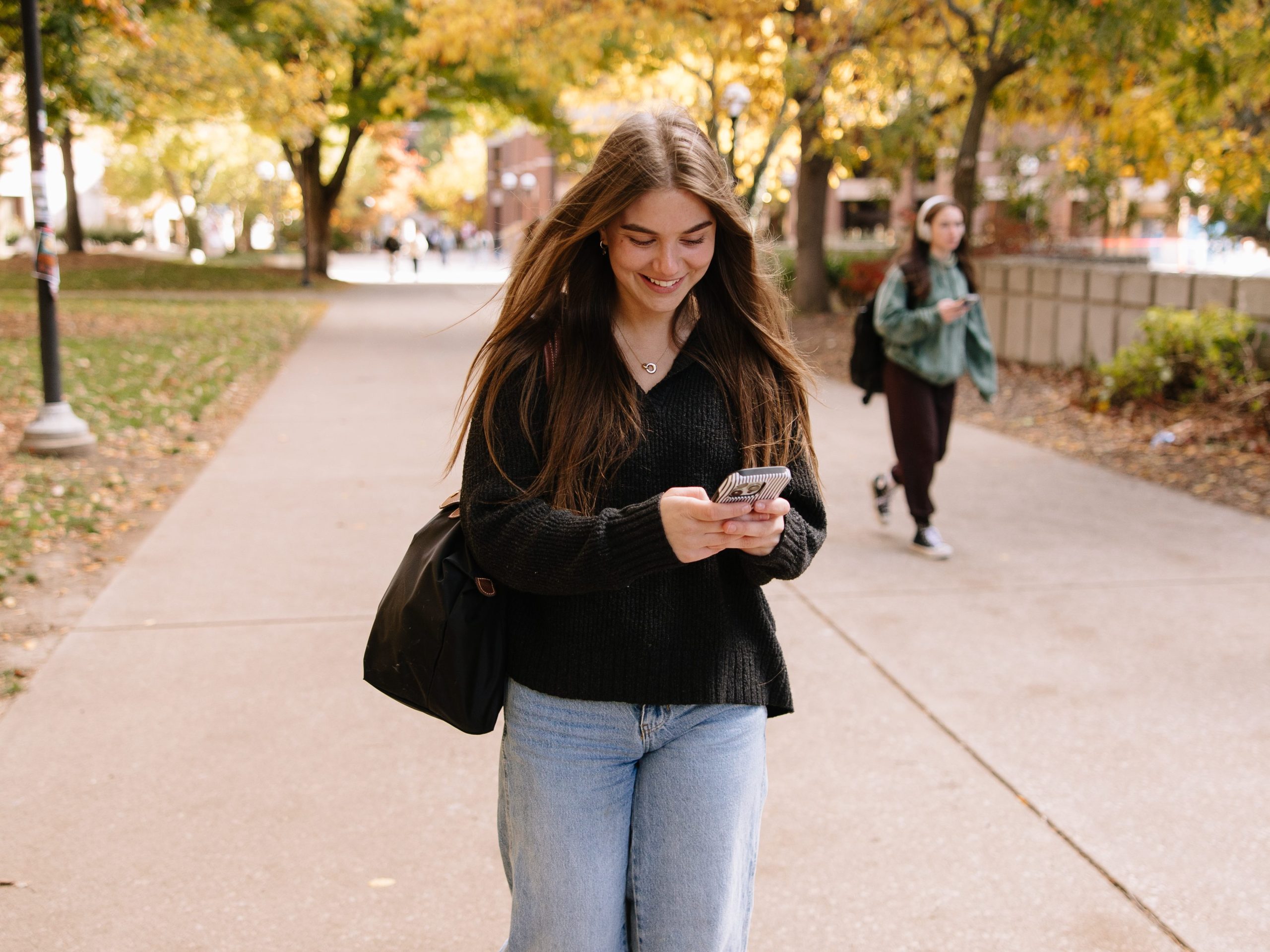 University of Michigan student looking at housing options on her phone in Ann Arbor.