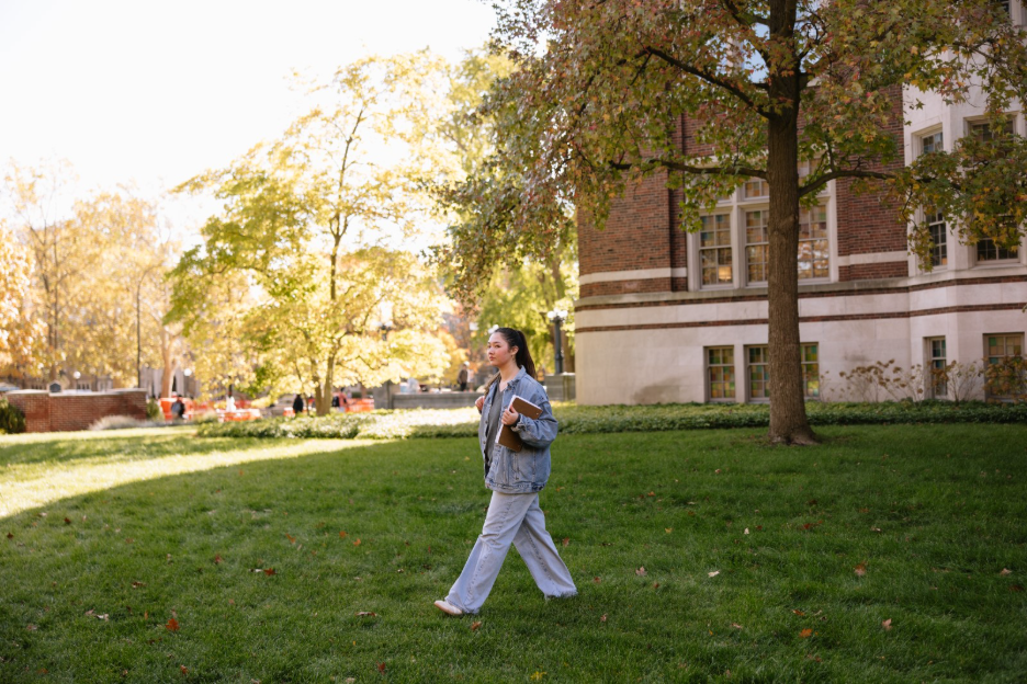 A University of Michigan student walking through the Law Quad on central campus in Ann Arbor.